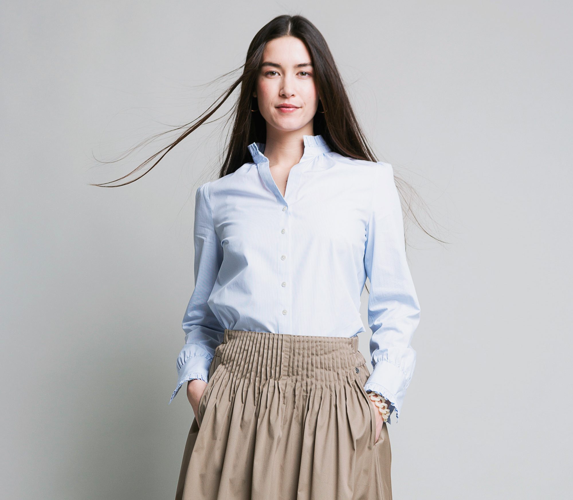 Model Portrait in hellblauer langarmbluse Bluse und ROCKMACHERIN Rock Windach vor grauem Hintergrund ©ROCKMACHERIN